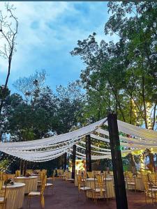 a group of tables and chairs with a white canopy at Shankars Resort in Guwahati