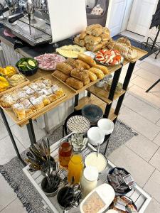 a table filled with different types of bread and pastries at Clown and Bard Hostel in Prague