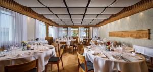 a dining room with tables and chairs with white tablecloths at Hotel Restaurant Schiff in Pfäffikon