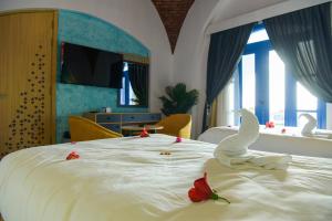 a bedroom with a white bed with swans on it at New Panorama Resort in Fayoum +44 photos
