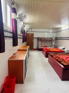 a large room with three beds in it at MSP Amma Cottage in Munnar