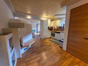a kitchen with white cabinets and a wooden floor at Feines Alpennest in Hopfgarten im Brixental +54 photos