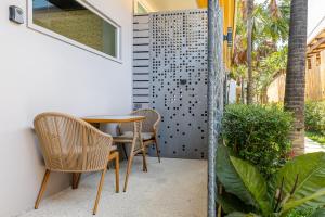 a patio with a table and chairs and a fence at The Strand Resort Samui in Bangrak Beach