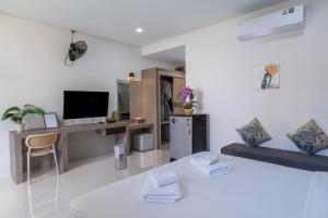 a white living room with a bed and a desk at The Strand Resort Samui in Bangrak Beach