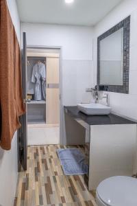 a bathroom with a sink and a toilet and a mirror at The Strand Resort Samui in Bangrak Beach