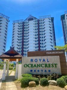 a hotel sign in front of two tall buildings at Jono's Flat Royal Oceancrest in Lapu Lapu City