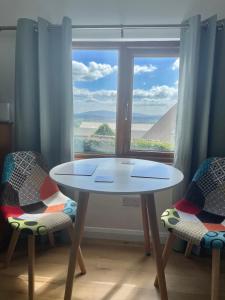 a table and two chairs in front of a window at The Orchard Cabin in Cardington