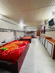 a large room with two beds and a tv at MSP Amma Cottage in Munnar