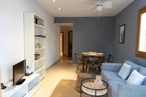 a living room with a blue couch and a table at APARTAMENTO EL ROJO in Can Picafort