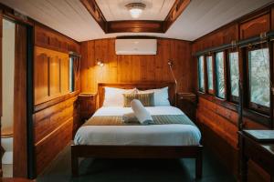 a bedroom with a bed in a wooden room at Glasshouse Mountains Ecolodge in Glass House Mountains +92 photos