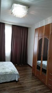 a bedroom with a bed and a dresser with a mirror at Saburtalo VIP in Tbilisi City