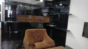 a chair in a room with a black wall at Saburtalo VIP in Tbilisi City +2 photos