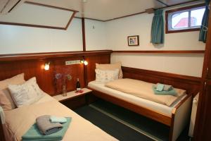 a bedroom with two beds in a boat at Hotelboat Fiep in Amsterdam