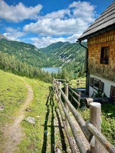 a fence next to a building with a view of a lake at Apartmán Grimming in Tauplitz
