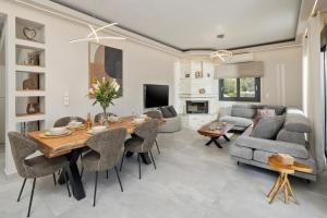a living room with a table and chairs and a couch at Villa Kouros P&A in Áfra