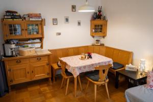 a room with a table with chairs and a kitchen at Apartmán Grimming in Tauplitz +4 photos