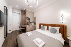 a bedroom with a large bed and a kitchen at Rynok Square Pidzemelya in Lviv