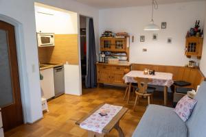 a living room with a table and a kitchen at Apartmán Grimming in Tauplitz