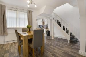 a kitchen and dining room with a table and a staircase at Freshly Renovated, Feels Like Home, Sleeps 3 in Chester-le-Street