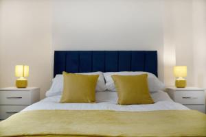 a bedroom with a large bed with two yellow pillows at Freshly Renovated, Feels Like Home, Sleeps 3 in Chester-le-Street