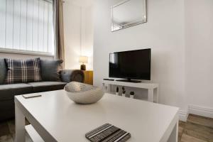 a living room with a white table and a tv at Freshly Renovated, Feels Like Home, Sleeps 3 in Chester-le-Street +12 photos