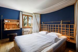 a bedroom with a large bed with blue walls at Hotel Restaurant Schiff in Pfäffikon