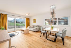 a living room with a table and a couch at Wiesenblick Residences - by myNests in Haus im Ennstal