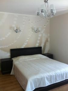 a bedroom with a bed with two lights on the wall at Villa Anna in Apšuciems