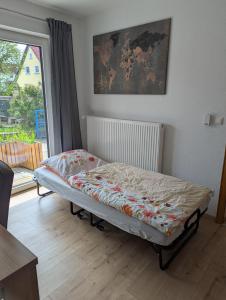 a bed sitting in a room with a window at Ferienwohnung Rosenbaum in Rannungen