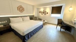 a hotel room with a bed and a chair at StarRay Hotel Jakarta Mangga Dua Square in Jakarta