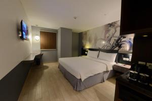 a hotel room with a bed and a television at StarRay Hotel Jakarta Mangga Dua Square in Jakarta