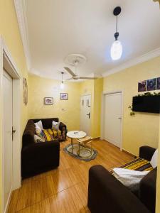 a living room with a couch and a table at CozyQ Apt in Aqaba +2 photos