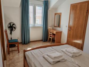 a bedroom with a bed and a desk and a window at Apartments Sofija in Slatine