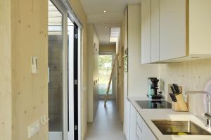 a kitchen with white cabinets and a sink at Noardewyn - Ecohuisjes Terschelling in Midsland
