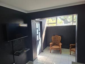 a room with two chairs and a window at Grace Villas 1 in East London
