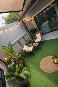 a balcony with chairs and a table and plants at Greeny garden house in Ban Na Sat