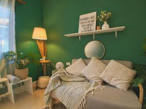 a green room with a bed and a green wall at Greeny garden house in Ban Na Sat