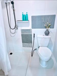 a white bathroom with a toilet and a shower at Greeny garden house in Ban Na Sat