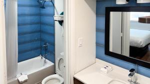 a bathroom with blue walls and a toilet and a sink at Motel 6 Classic Galveston, TX Beach-Seawall in Galveston
