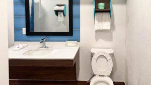 a bathroom with a sink and a toilet and a mirror at Motel 6 Classic Galveston, TX Beach-Seawall in Galveston