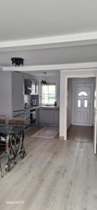 a large kitchen with white walls and wooden floors at Ferienwohnung am Waldrand 1 in Stary Przybsław
