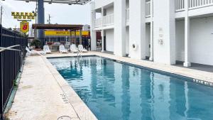 a swimming pool in front of a building at Motel 6 Classic Galveston, TX Beach-Seawall in Galveston