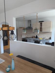 a kitchen with a counter with a table in front of it at Ferienwohnung Rosenbaum in Rannungen +3 photos