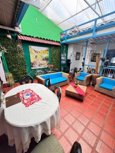 a room with a table and chairs and a green wall at hospedaje casa de niebla in Salento
