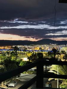 a view of a city from a balcony at night at CozyQ Apt in Aqaba