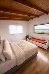 a bedroom with a large bed and a window at CIELO AUSTRAL house overlookin the ocean in Ushuaia