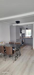 a kitchen with a table and chairs in a room at Ferienwohnung am Waldrand 1 in Stary Przybsław +5 photos