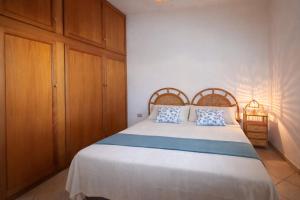a bedroom with a large white bed with blue pillows at Rosa Fronte Mare in Torre Mozza