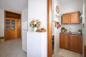 a kitchen with a white refrigerator and a basket of fruit at Rosa Fronte Mare in Torre Mozza