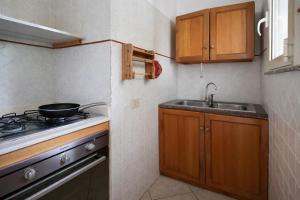 a small kitchen with a stove and a sink at Rosa Fronte Mare in Torre Mozza